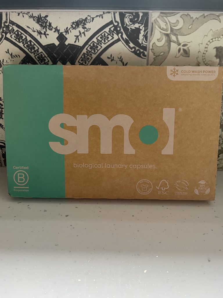 Cardboard box with the word SMOL written on it, resting on a white worktop