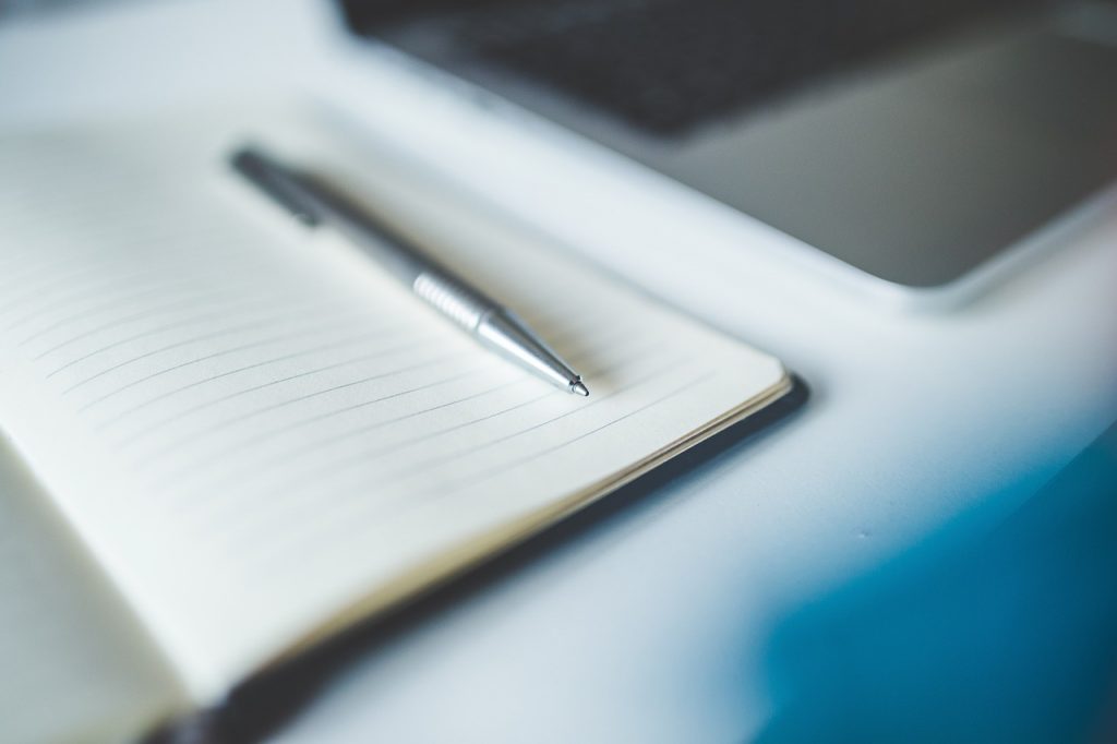 Blank lined note page with a silver pen resting on it