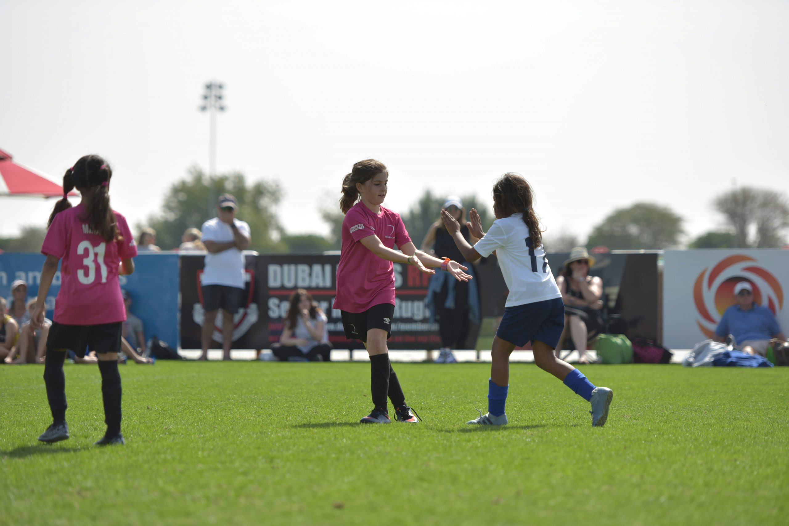 Two girls on a football field congratulating each other