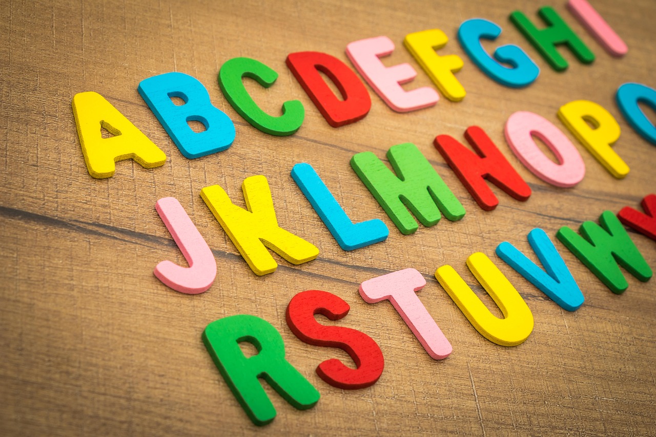 Multicoloured capital alphabet letters on a wooden background