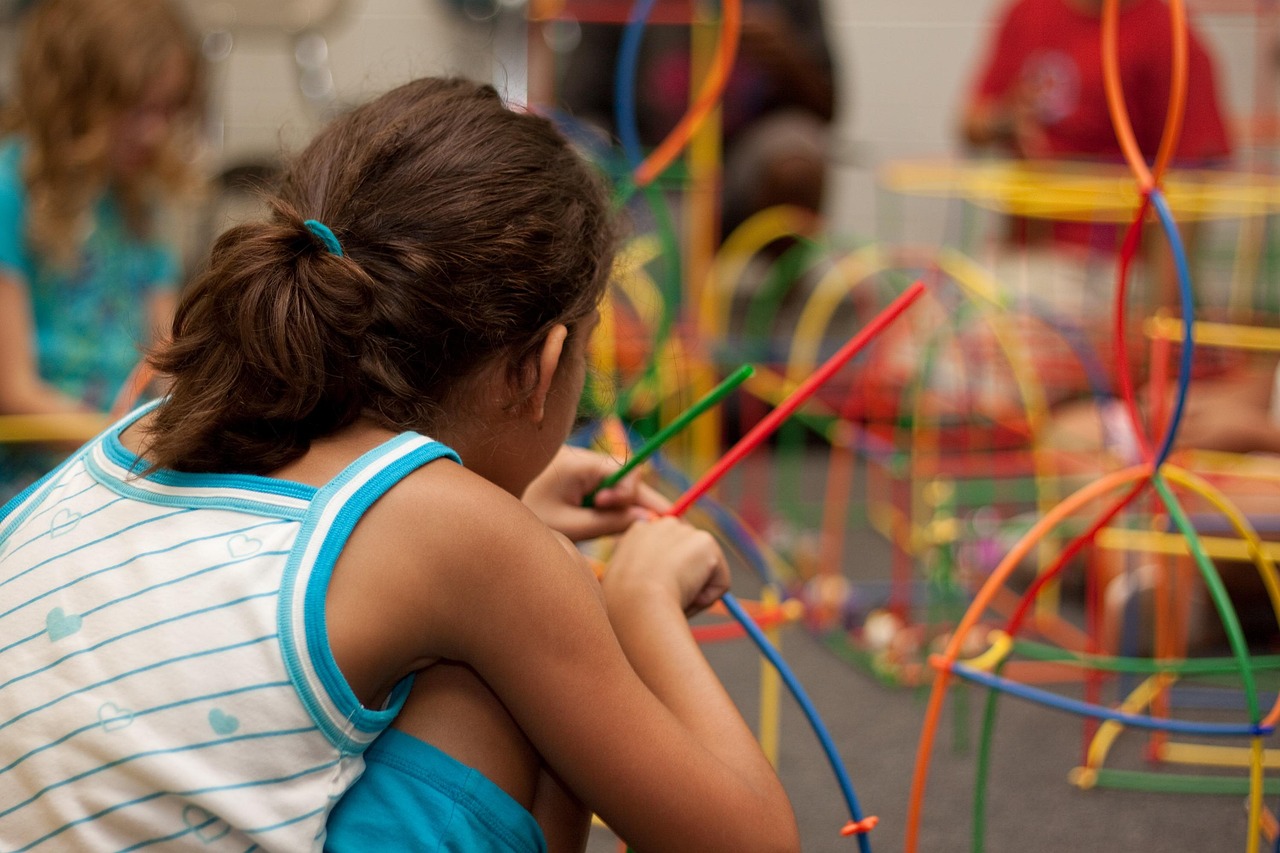 Child with their back to the screen looking at play and learning equipment