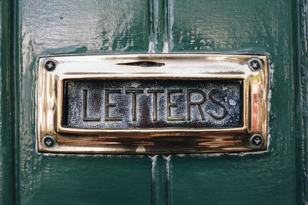 A letterbox on a green door representing post-adoption contact taking place through the letterbox system
