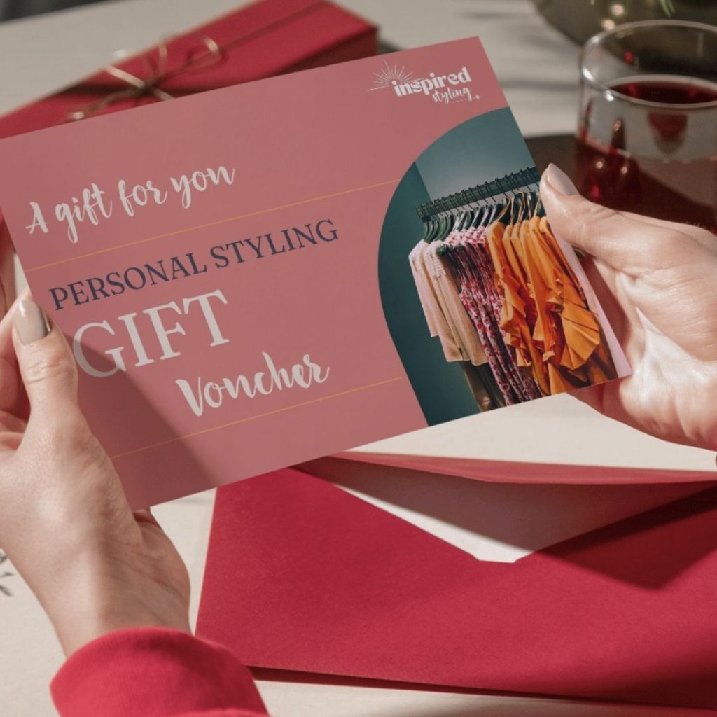 A pair of women's hands holding a pink gift voucher for Inspired Styling