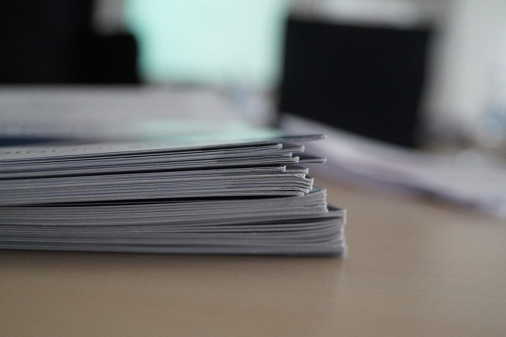 A pile of papers stacked on a desk representing adoption legal proceedings
