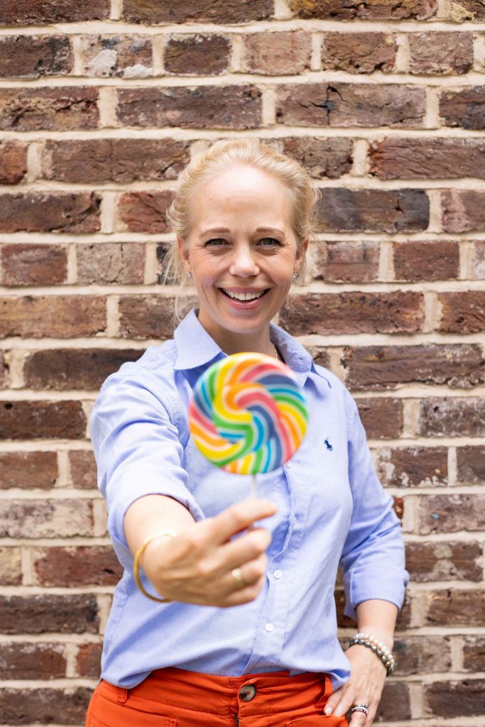 Image of Femke Harris, the creator of Merry Go Round, holding a lollipop as she shares why renting your baby kit is the perfect option for adoptive parents
