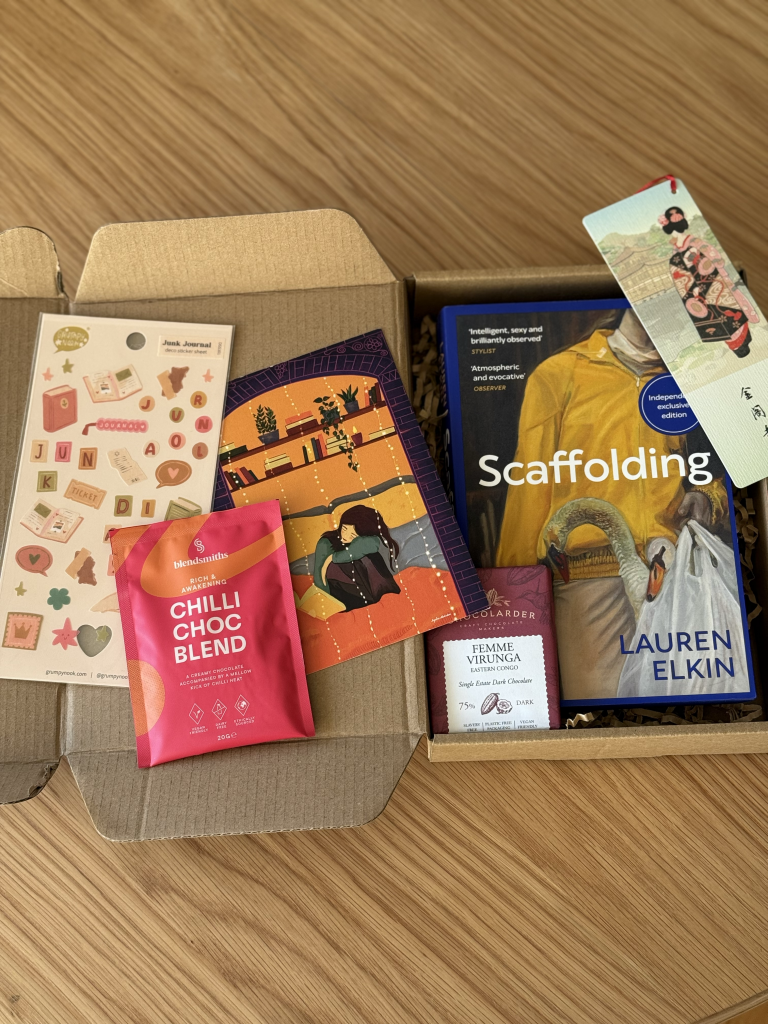 The contents of the Secret Book Gift Hamper including a book, bookmark and chocolate