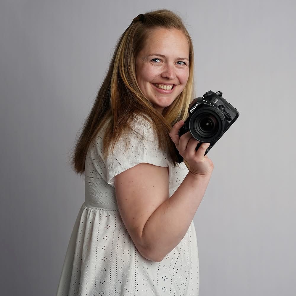 Lucy Holding holding her camera, smiling