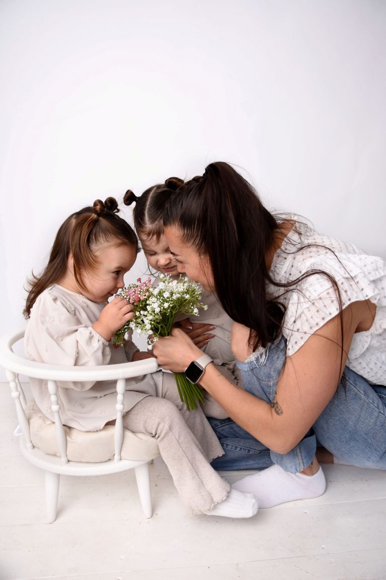 A mum laughing with her two children who are all photographed from the side