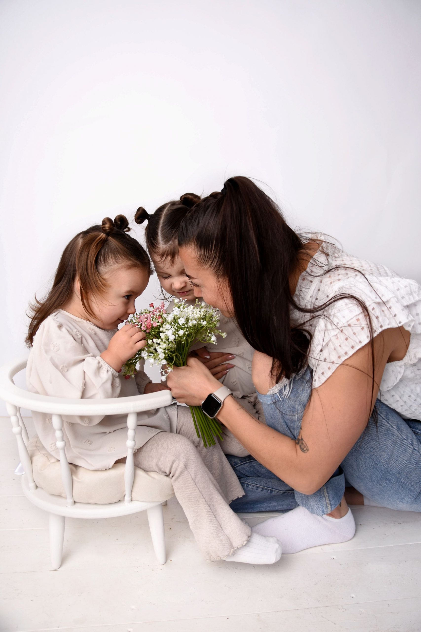 A mum laughing with her two children who are all photographed from the side