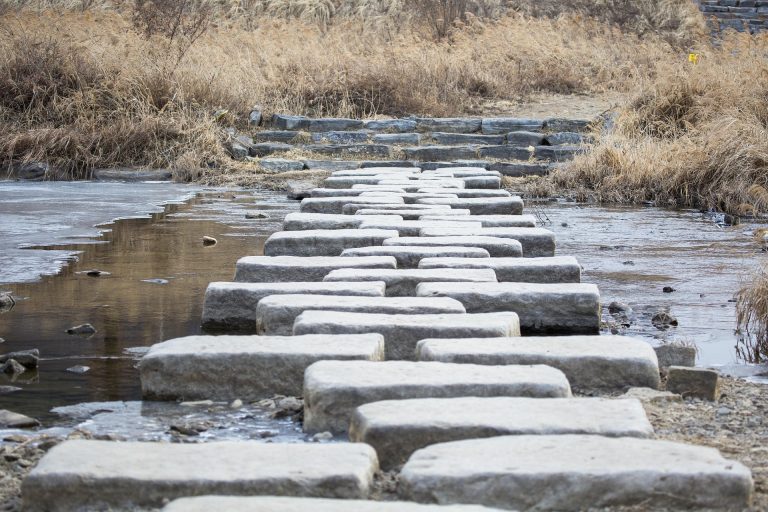 Stepping stones across a river representing solution-focused hypnotherapy