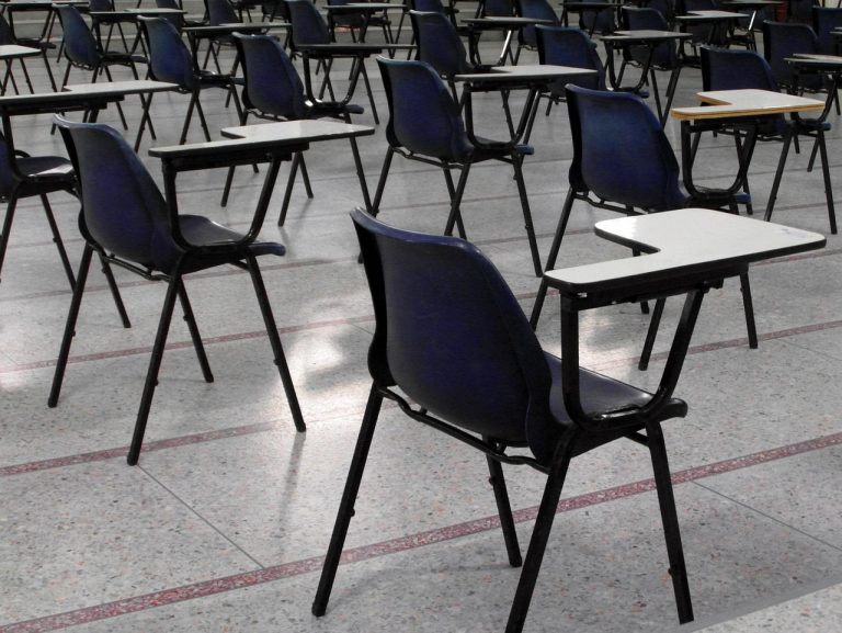 A room of empty chairs set up for an exam highlighting the parent guide to survive exams