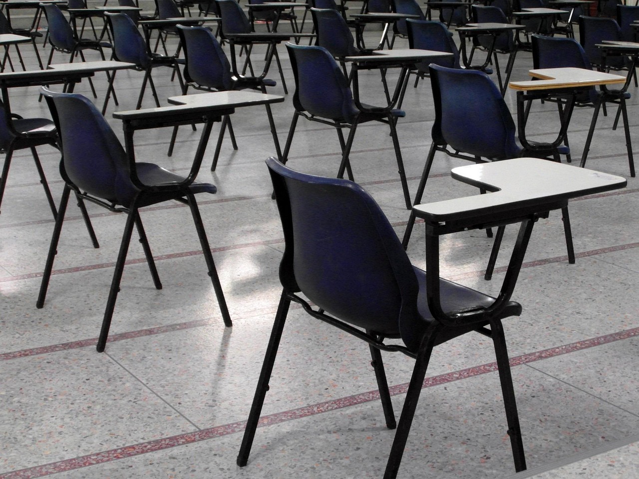 A room of empty chairs set up for an exam highlighting the parent guide to survive exams