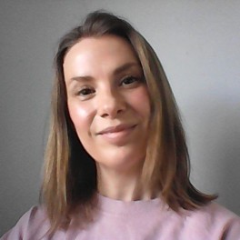 Headshot of Beckie Beard, the Perimenopause Mom, wearing a pink jumper against a pale grey background