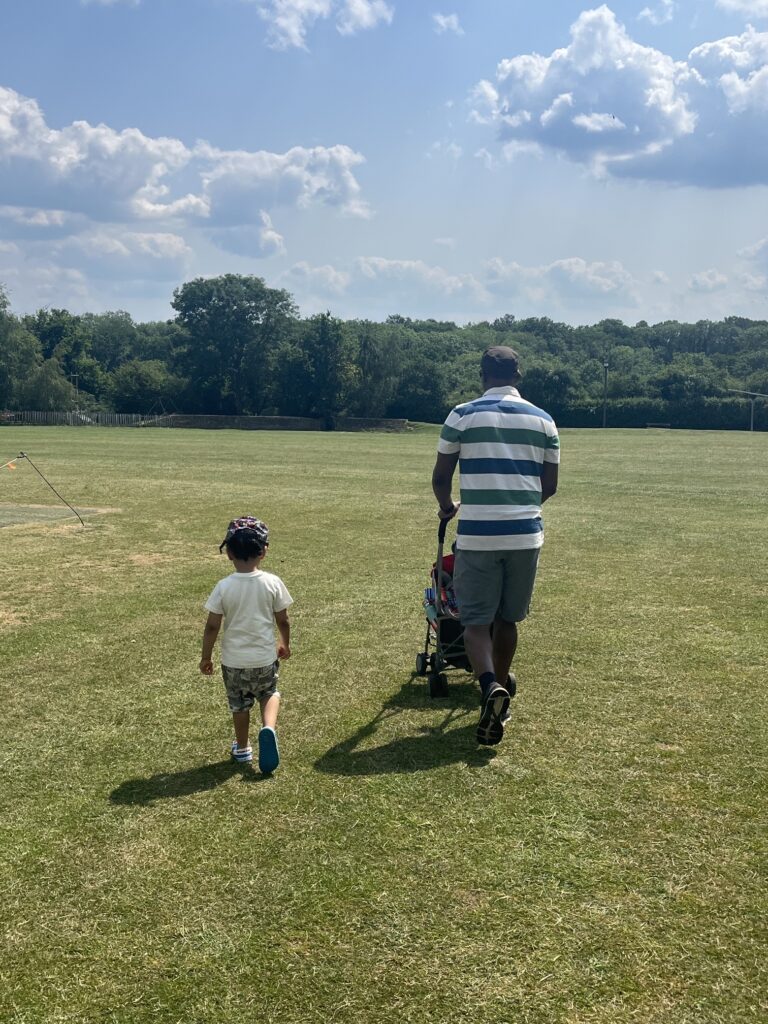The back image ofafather and son walking in a field he path to fatherhood