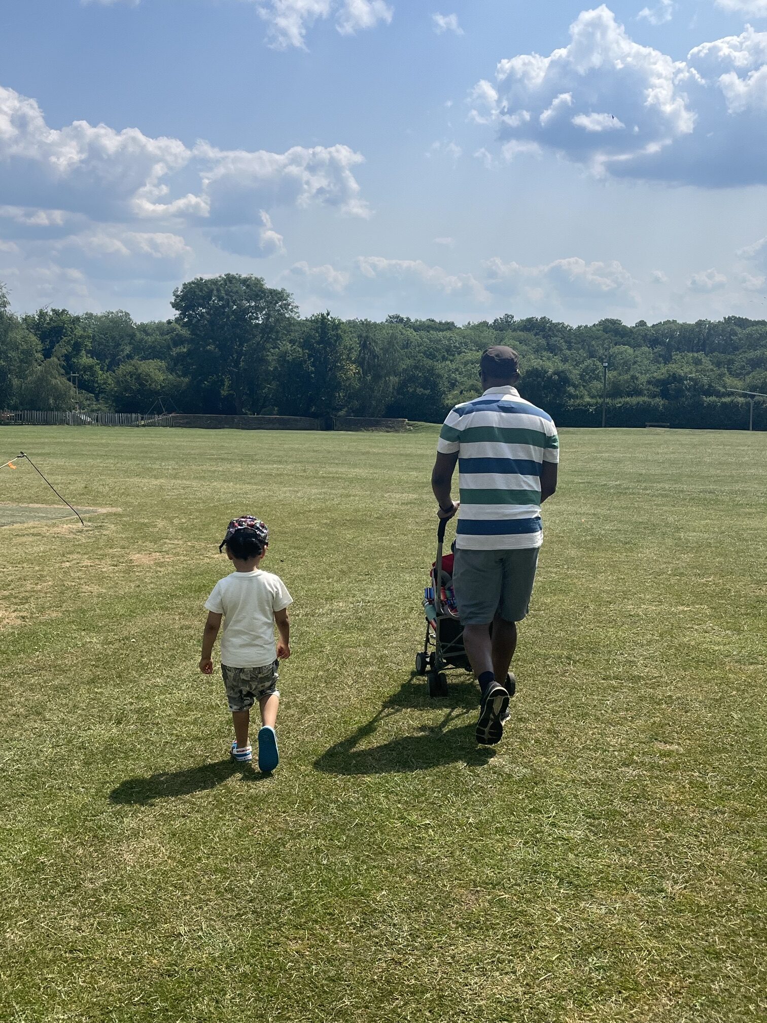 The back image ofafather and son walking in a field he path to fatherhood